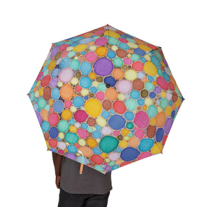 Colorful polka dot umbrella held by a person on a white background