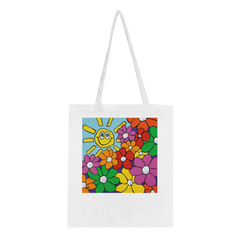 A high-quality white canvas tote bag featuring "Bouquet & Sun," a vibrant original artwork by MFPA mouth painter Lars Hollerer, depicting a cheerful smiling sun and a colorful garden of flowers.