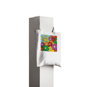 A durable white canvas tote bag featuring an original mouth-painted illustration by MFPA artist Lars Hollerer. The design shows a vibrant garden of colorful flowers and a cheerful, smiling sun against a bright blue sky.